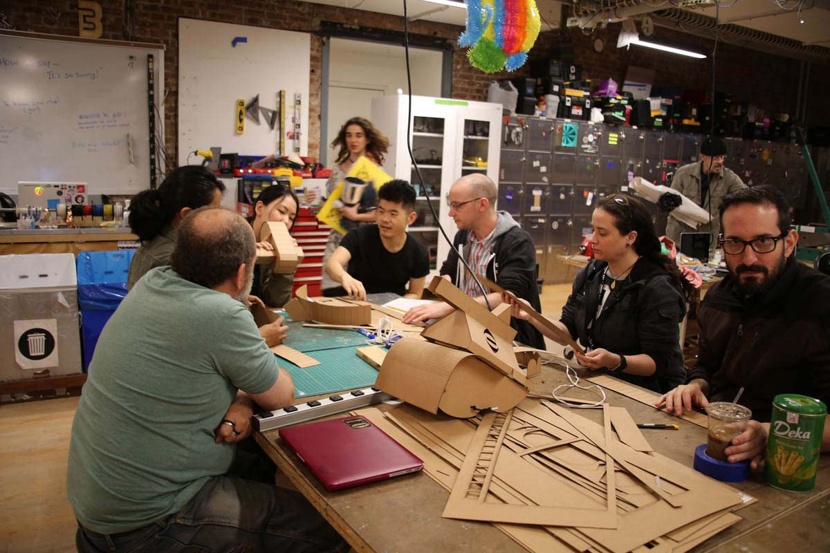 a group of people working with cardboard